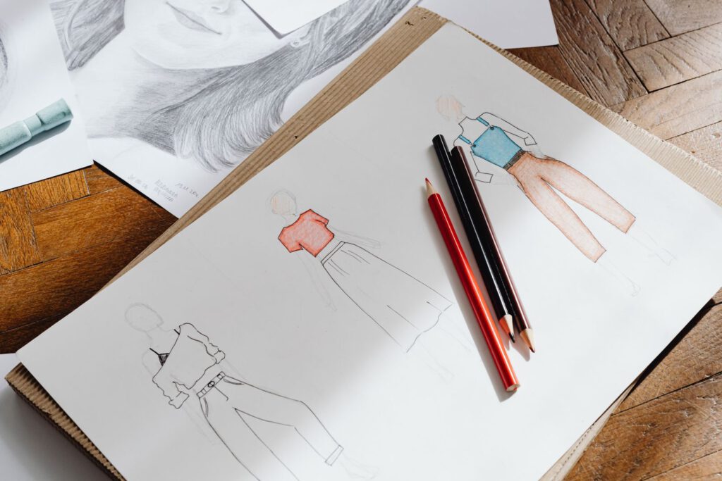 Coloured fashion sketches and pencils on a sketchbook, illustrating what intellectual property protects