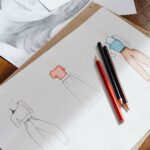 Coloured fashion sketches and pencils on a sketchbook, illustrating what intellectual property protects