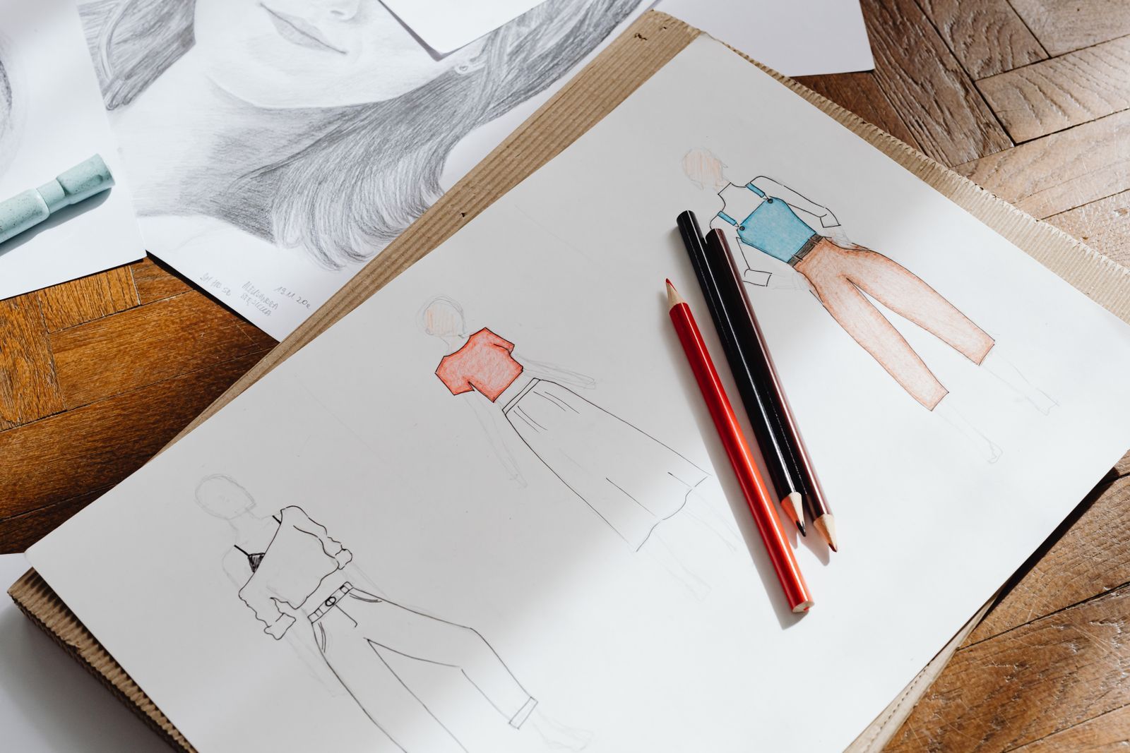 Coloured fashion sketches and pencils on a sketchbook, illustrating what intellectual property protects
